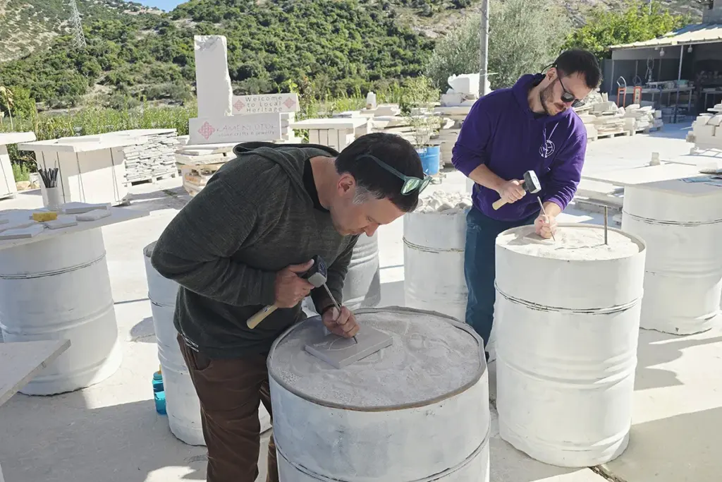 Two brothers carving Brač stone for the first time during the Journey Through Stone workshop at Kameni otok