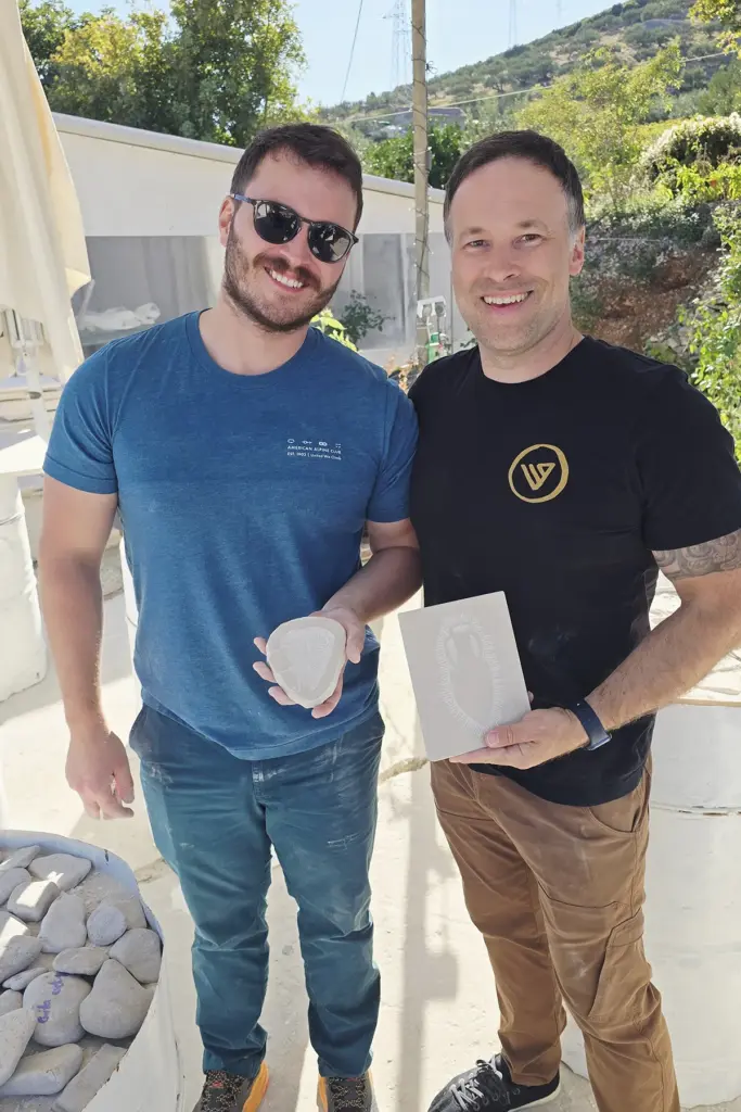 Two brothers proudly displaying their handcrafted Brač stone reliefs after completing the Journey Through Stone workshop at Kameni otok