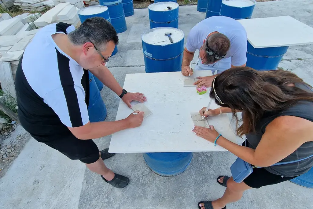 Participants sketching their designs on Brač stone before carving during the Journey Through Stone workshop at Kameni otok