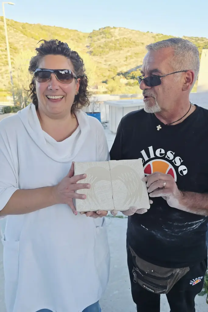 Workshop participant proudly displaying a hand-carved Brač stone relief created during the Journey Through Stone experience at Kameni otok