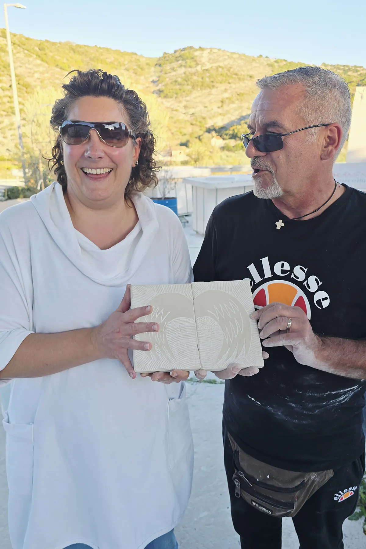 Workshop participant proudly displaying a hand-carved Brač stone relief created during the Journey Through Stone experience at Kameni otok