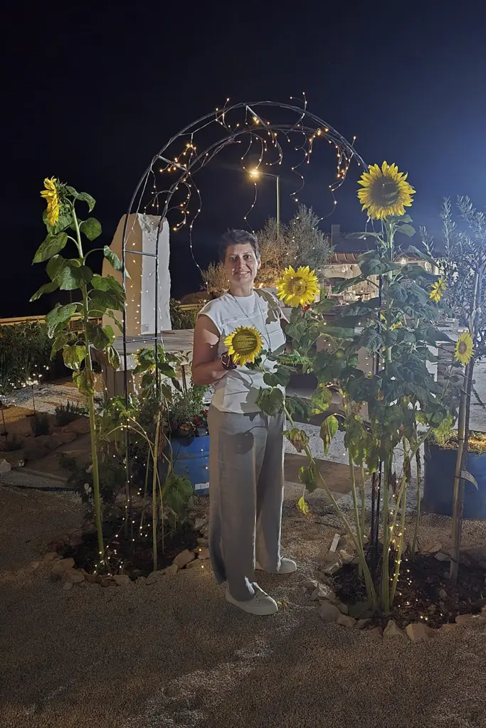 Željka Frančeski standing among sunflowers during the Stone Under the Stars evening experience at Kameni otok on Brač